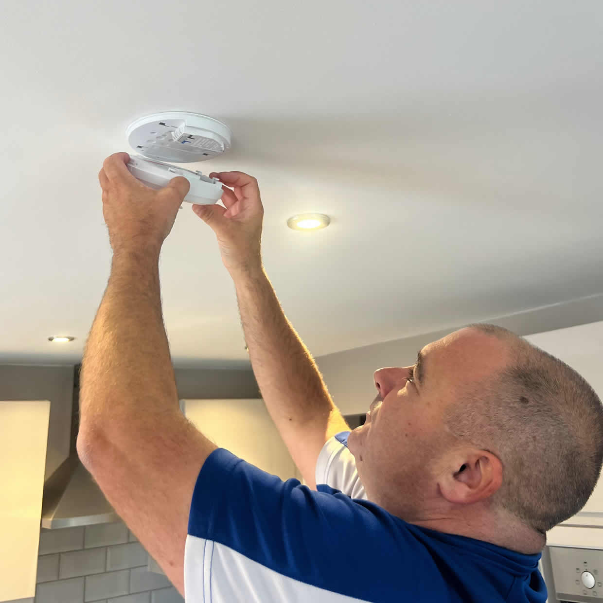 Smoke alarm installer fitting an alarm in a Folkestone property